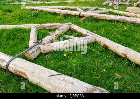 connexion à bande en acier forgé de poutres en bois pour cadre de poutre de support de toit posé sur l'herbe verte le jour de l'été Banque D'Images