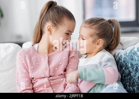 deux petites filles ou sœurs souriantes à la maison Banque D'Images