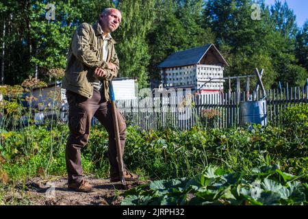 Le fermier se tient avec une pelle dans le jardin. Préparation du sol pour la plantation de légumes. Concept de jardinage. Travaux agricoles sur la plantation Banque D'Images
