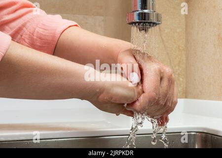 Gros plan de belles mains féminines sous l'eau courante Banque D'Images