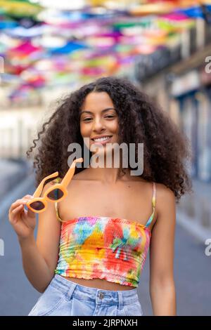 fille avec cheveux afro portant ses lunettes de soleil Banque D'Images