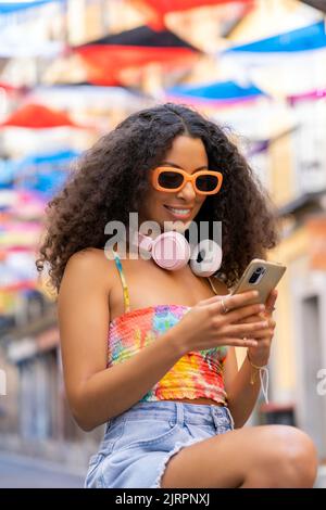 fille avec cheveux afro à l'aide de son smartphone Banque D'Images