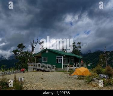 Paparoa Grande promenade, parc national de Paparoa / Aotearoa / Nouvelle-Zélande - 14 février 2022: Randonneurs et motards de montagne séjournant à Pororari Hut. Banque D'Images