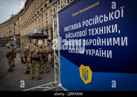 Kiev, Ukraine. 23rd août 2022. Les soldats ukrainiens se trouvent à côté du panneau d'affichage de l'exposition à Kiev. Consacrée à la prochaine Journée de l'indépendance de l'Ukraine, et près de 6 mois après l'invasion à grande échelle de l'Ukraine sur 24 février, la capitale du pays Kiev a organisé une exposition sur la rue principale de la rue Khreschaytk montrant plusieurs équipements militaires détruits, Chars et armes des forces armées de la Fédération de Russie (AFRF).alors que la pleine invasion russe de l'Ukraine a commencé sur le 24 février, la guerre a tué de nombreux civils et soldats, près de 9000 militaires ukrainiens Banque D'Images