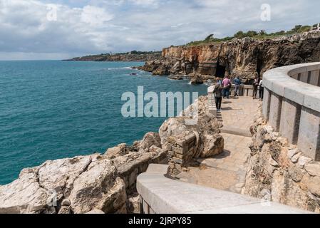 Un groupe de touristes appréciant la belle vue sur la mer tranquille à Boca de Inferno, Cascais Banque D'Images