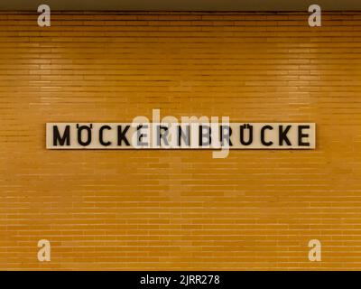 Station de métro Möckernbrücke à Berlin. Ancien design avec une façade murale carrelée de jaune. Lettres noires sur un tableau blanc. Panneau de nom de la station de métro. Banque D'Images