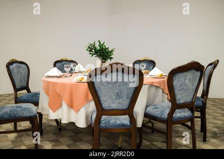 Disposition des sièges d'un mariage avec une table de mariage ronde au centre d'une salle à manger coloniale avec rideaux de plafond blanc fin. Banque D'Images