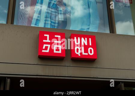 Étiquette de mode japonaise Uniqlo sur la façade d'un magasin. Logo de la marque de vêtements à l'extérieur d'un bâtiment. Publicité avec un emblème de marque éclairé. Banque D'Images