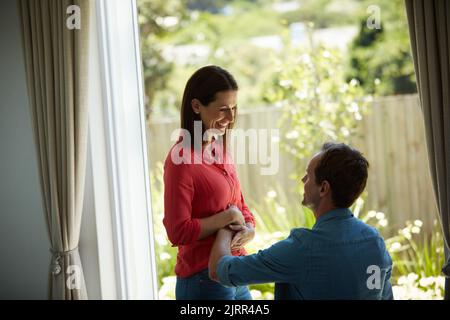 Un homme qui touche son estomac enceinte à la maison est impatient de voir sa parentalité. Banque D'Images