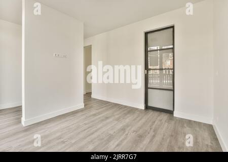 Lit confortable avec couette et oreillers situés près de la chaise et du mur avec peinture encadrée contre l'armoire dans la chambre éclairée Banque D'Images