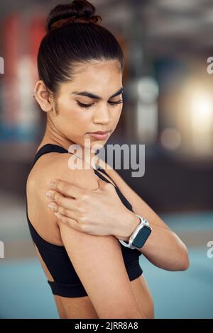 Blessures, blessures et douleurs aux épaules pour une athlète féminine tenant son bras douloureux à la salle de gym. Femme active, en forme et athlétique souffrant de muscle Banque D'Images