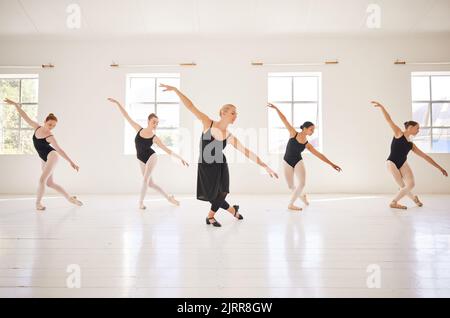 Ballet, étudiants en danse et professeur en classe pour la pratique, la formation et la performance en studio. Des danseurs d'art classique se déplaçant avec équilibre, grâce et Banque D'Images