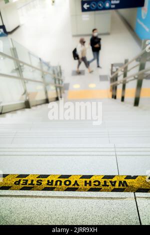 Observez votre autocollant de marchepied sur les escaliers de l'espace public avec des personnes à l'arrière-plan Banque D'Images