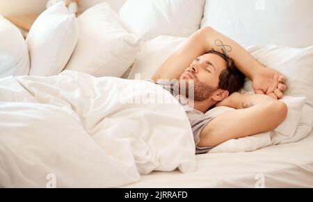 Détendez-vous, la maison et la chambre pour dormir homme couché le matin dans la chambre à coucher maison, l'hôtel ou l'hospitalité de luxe Airbnb. Fatigue, épuisement ou personne fatiguée Banque D'Images