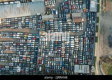Vue aérienne du grand parking de junkyard avec des rangées de voitures brisées jetées. Recyclage des vieux véhicules Banque D'Images