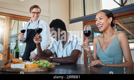 Serveur, amis de diversité ou ferme de dégustation de vins avec verre d'alcool rouge dans le restaurant de campagne. Sourire heureux ou apprendre le lien de couple ou Banque D'Images