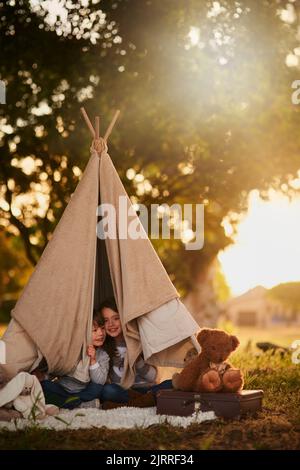 Nous À plus. Portrait de deux jolis petits frères et sœurs jouant ensemble dans une tipi à l'extérieur. Banque D'Images