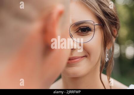 Gros plan portrait une femme excitée, souriante et saucy aux cheveux en lunettes modernes avec rebord regardant l'appareil photo. Mauvaise vision Banque D'Images