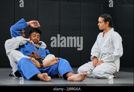 Groupe d'athlètes dans un entraînement de combat d'arts martiaux pour la forme physique dans un studio d'entraînement. Une équipe active, sportive et diversifiée de sportifs pratiquant la sparring Banque D'Images
