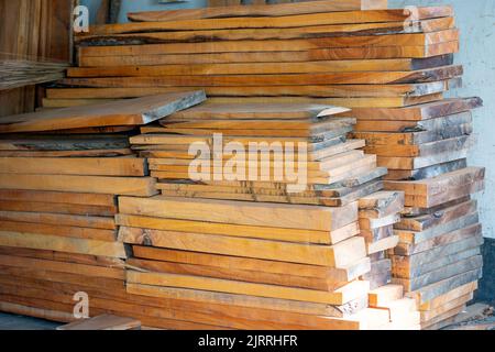 Bois d'eucalyptus avec arrière-plan flou. Les planches en bois sont stockées pour la fabrication de meubles en bois. Mise au point sélective, espace de copie. Banque D'Images