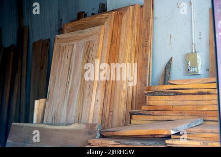 Bois d'eucalyptus avec arrière-plan flou. Les planches en bois sont stockées pour la fabrication de meubles en bois. Mise au point sélective, espace de copie. Banque D'Images