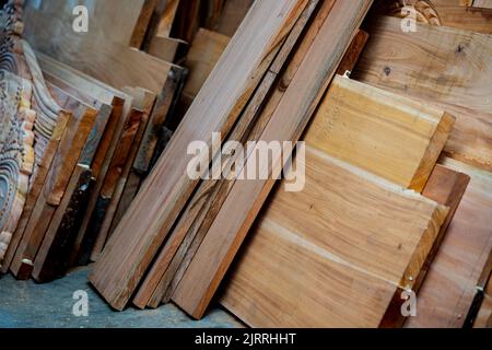 Bois d'eucalyptus avec arrière-plan flou. Les planches en bois sont stockées pour la fabrication de meubles en bois. Mise au point sélective, espace de copie. Banque D'Images