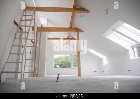 chantier moderne de construction grenier fraîchement peint, le plancher est encore chape, les murs sont blancs Banque D'Images