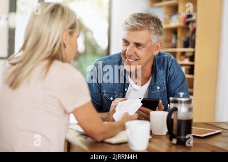 Couple payer des factures par téléphone en ligne, travailler sur le budget de financement et de banque sur smartphone dans la cuisine à la maison. Homme heureux et femme prêt pour Banque D'Images