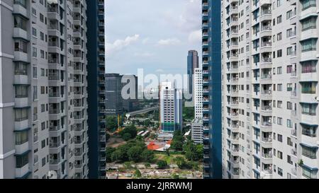 Vol aérien vers l'avant vers les gratte-ciels du centre-ville entre deux gratte-ciel en verre à Jakarta, Indonésie Banque D'Images