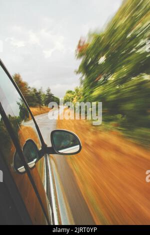 Exposition longue du point de vue d'une voiture lors d'un voyage dans la campagne par une journée nuageux. Banque D'Images