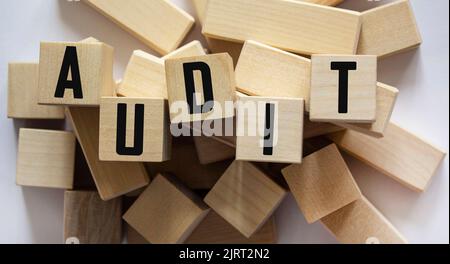 Le mot Audit est écrit sur des cubes en bois se tenant sur un fond clair Banque D'Images