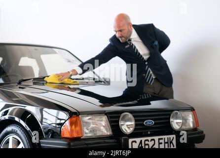 Arwel Richards, spécialiste automobile classique de Silverstone Auctions, polit l'Escort RS Turbo 1985 de Ford, qui appartenait auparavant à Diana, princesse de Galles, sur le circuit de course de Silverstone près de Towcester, dans le Northamptonshire, avant qu'il ne passe sous le marteau samedi aux Silverstone Classics. Date de la photo: Vendredi 26 août 2022. Banque D'Images