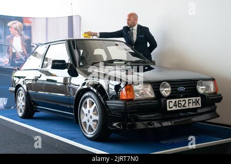 Arwel Richards, spécialiste automobile classique de Silverstone Auctions, polit l'Escort RS Turbo 1985 de Ford, qui appartenait auparavant à Diana, princesse de Galles, sur le circuit de course de Silverstone près de Towcester, dans le Northamptonshire, avant qu'il ne passe sous le marteau samedi aux Silverstone Classics. Date de la photo: Vendredi 26 août 2022. Banque D'Images