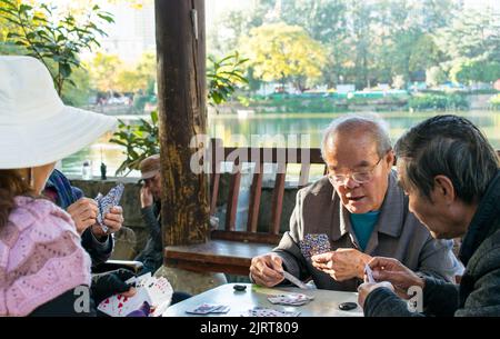 Un groupe de Chinois de premier plan jouant à un jeu de cartes à Kunming. Banque D'Images