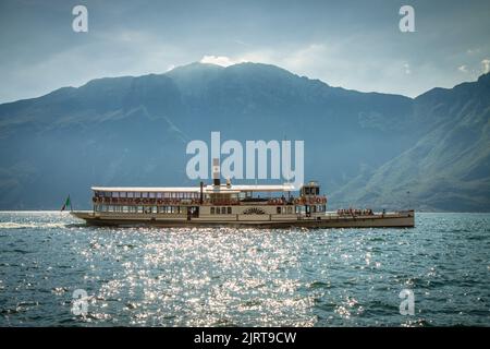 La belle vue du bateau à vapeur traditionnel flottant sur le lac Lago di Garda, Limone Sul Garda - Malcesine, Italie. Arrière-plan HD avec moutai Banque D'Images