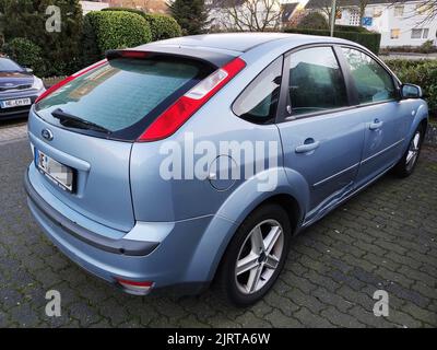 Vue arrière d'une voiture bleue Ford Focus MK2 de 2005 garée dans la rue avec des bosses et des rayures Banque D'Images