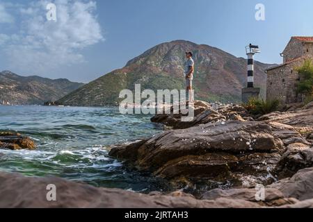 Homme touristes debout sur la falaise près du phare au Monténégro Banque D'Images