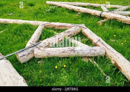 connexion à bande en acier forgé de poutres en bois pour cadre de poutre de support de toit posé sur l'herbe verte le jour de l'été Banque D'Images