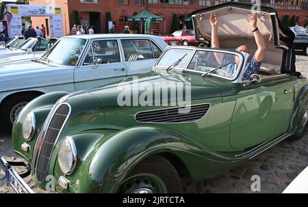 Nauen, Allemagne. 26th août 2022. Le conducteur d'un cabriolet sportif EMW 327/2 (construit en 1953) ouvre sa capote lors de l'ADAC Landpartie Classic au domaine Stober. Environ 100 voitures classiques de 33 fabricants ont fait un tour de voiture classique dans la région de Havelland. Credit: Bernd Settnik/dpa/Alay Live News Banque D'Images