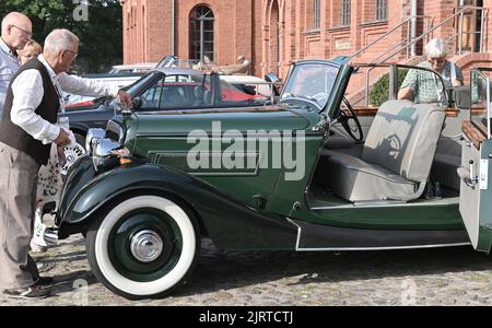 Nauen, Allemagne. 26th août 2022. Le conducteur d'un Wanderer W50 C Gläser Cabriolet (construit en 1936) vérifie son véhicule avant le début de l'ADAC Landpartie Classic à la propriété Stober. Environ 100 voitures classiques de 33 fabricants commencent sur la rampe de voiture classique dans la région de Havelland. Credit: Bernd Settnik/dpa/Alay Live News Banque D'Images