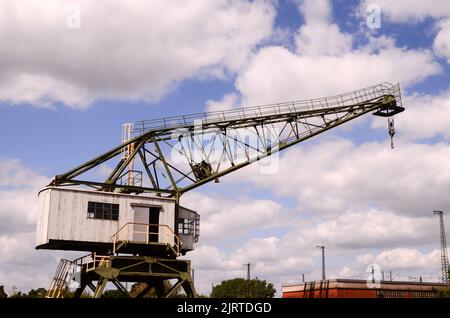 Grue de port en bois d'époque sur un ciel bleu nuageux Banque D'Images