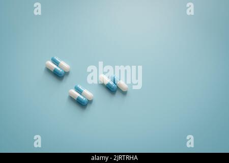 Paires de pilules de capsule d'antibiotique blanc-bleu sur fond bleu. Médicament antibiotique. Médicament sur ordonnance. Concept de pharmacologie et de dose recommandée. Pharma Banque D'Images