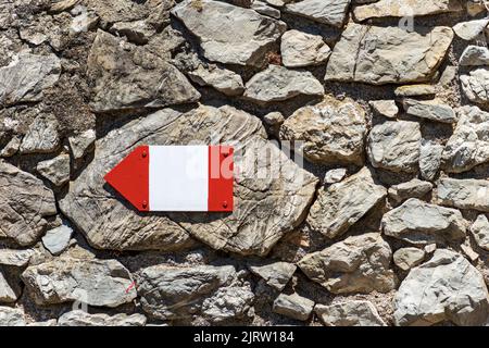 Gros plan d'un panneau directionnel rouge et blanc avec espace de copie sur un mur en pierre, sentier en Ligurie, Cinque Terre, Italie, Europe. Banque D'Images