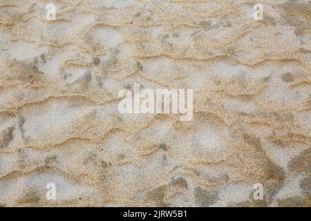 Textures de sable ondulées, structures de plage ondulées, ondulations et trous Banque D'Images