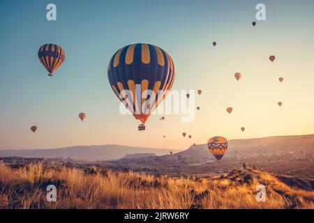 Un lever de soleil incroyable avec des ballons d'air chaud colorés au-dessus de la spectaculaire vallée de la Cappadoce. Contexte de votre concept de voyage. Paysage naturel d'été, matin Banque D'Images