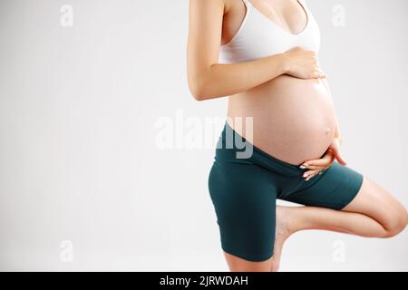 Jeune femme enceinte de yoga travaillant à faire la posture prénatale d'arbre, pose de yoga. Concept de grossesse en santé. Geste de Namaste enceinte Banque D'Images