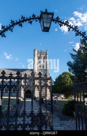 Prieuré de Christchurch, Dorset, Angleterre, Royaume-Uni, vue sur le site historique à travers les portes ornées et l'arche avec lampe Banque D'Images