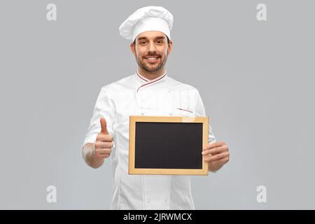 joyeux chef masculin montrant le tableau de surveillance et les pouces vers le haut Banque D'Images