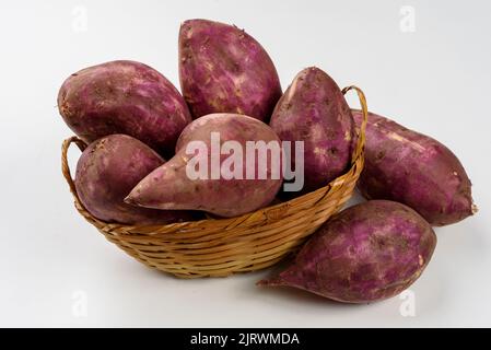 Patates douces dans un panier isolé sur fond blanc. Banque D'Images