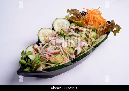 Cuisine japonaise. Octopus sunomono et kani kama dans le paquet de livraison isolé sur fond blanc. Banque D'Images